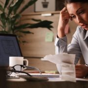 How will I pay all these bills? Rescisão indireta por pagamento por fora: trabalhadora preocupada analisando contas e dívidas financeiras