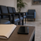 Sala de espera de clínica vazia com celular sobre a mesa, cena que ilustra o dano moral por negativa de cobertura do plano de saúde