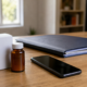 Celular sobre mesa ao lado de caixa de medicamento importado e pasta de documentos, representando a importação excepcional da Anvisa e a negativa do plano