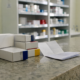 Caixas de medicamento pelo SUS e receita sem dados legíveis sobre balcão de farmácia pública