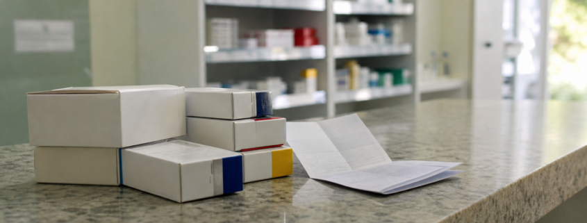 Caixas de medicamento pelo SUS e receita sem dados legíveis sobre balcão de farmácia pública
